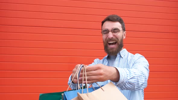 Portrait Happy Bearded Guy with Glasses Takes the Bags in His Hands Shopping in the Store