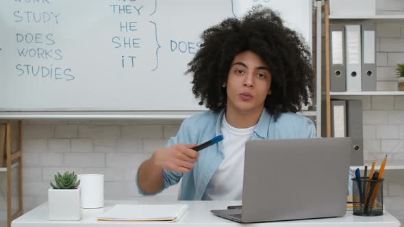 Online Tutor Pointing At Blackboard Explaining English Grammar Indoors