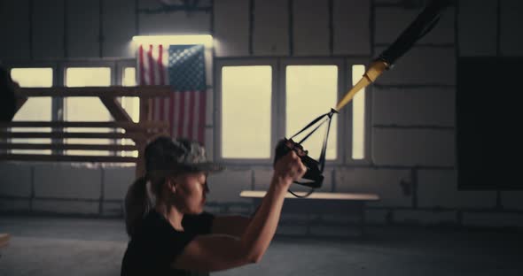 Strong Military Woman Doing TRX Lunge in Gym