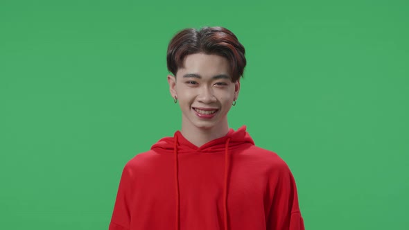 Young Asian Transgender Male Warmly Smiling On Green Screen Background In The Studio