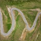 Drone footage of the grass field the winding road and driving car - VideoHive Item for Sale
