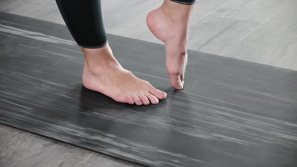 Closeup on Legs of Barefoot Woman on Mat Warming Up Preparing for Exercises