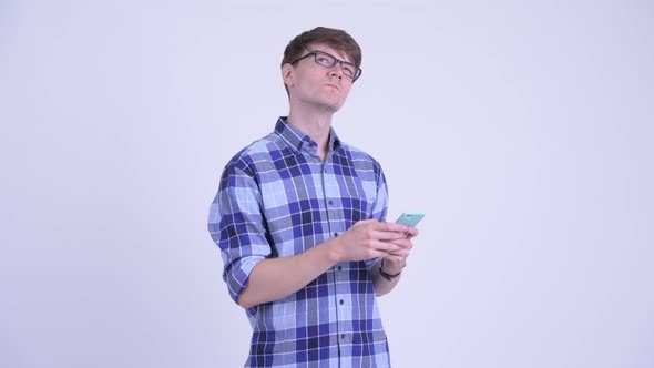 Happy Young Handsome Hipster Man Thinking While Using Phone