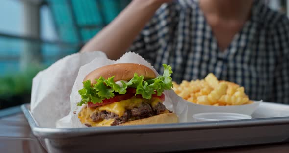 Woman eat burger in fast food restaurant