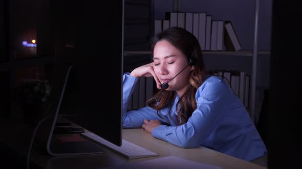 Asian female call center being tired, exhausted, overworked in front of computer