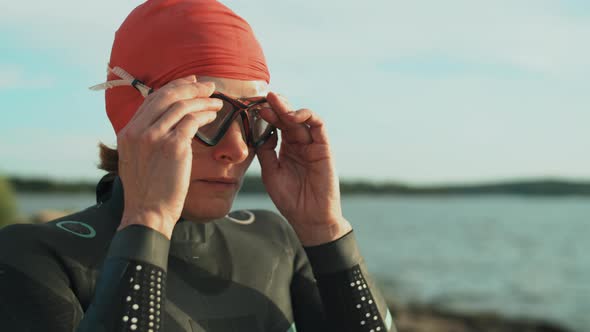 Female Triathlete Putting on Swimming Goggles