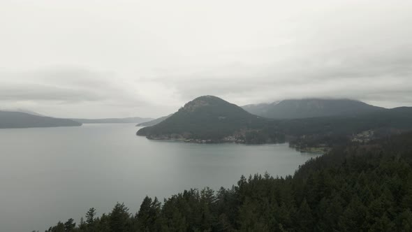 Misty gray skies touch the tops of peaks on Orcas Island, Washington, aerial panorama