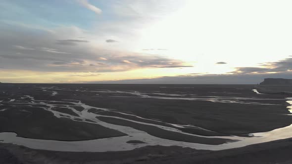 Aerial Panning Shot of Glacial Rivers at Sunrise.
