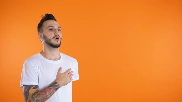 Young Man in Soccer Football Uniform Singing a Hymn Isolated at Orange Background