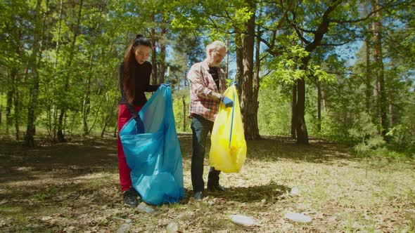 Charity Eco Activists Picking Up Plastic Waste and Garbage in Woodland