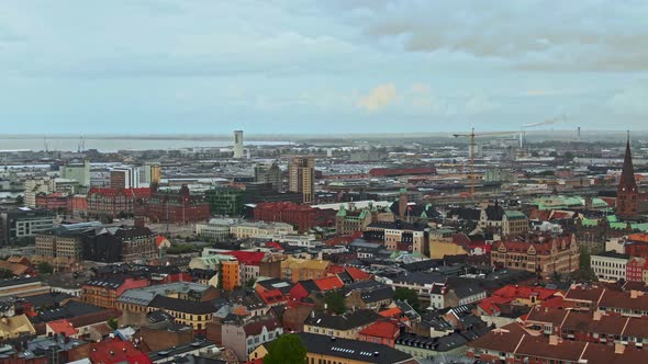 Colorful downtown rooftops of Malmo city in ascending drone view