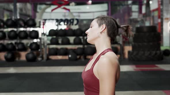 Athletic Woman Stretching Arms and Neck After Workout at the Gym