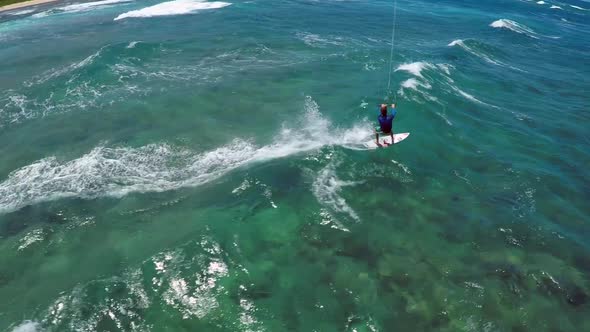 Aerial view of a man kitesurfing in Hawaii.