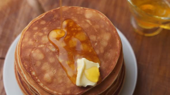 Pouring Syrup Over Stack of Fluffy Buttermilk Pancakes. Closeup View, Slow Motion Footage