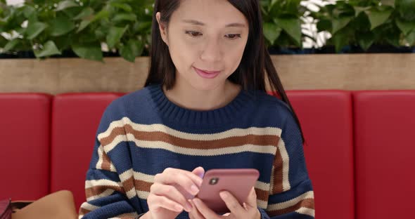 Woman check the sales on cellphone inside shopping center