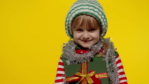 Kid Girl Christmas Elf Santa Helper Giving Present Gift Box To Camera