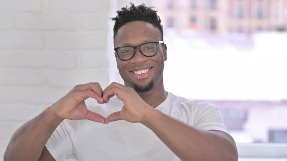 Portrait of Attractive Casual African Man Making Heart Shape