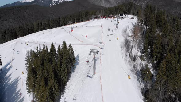 Aerial Ski Slopes with Skiers and Ski Lifts on Ski Resort. Snowy Mountain Forest