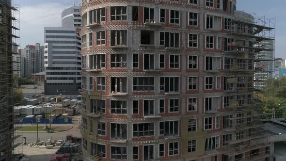 Aerial shot of construction of high-rise apartment building in city alt