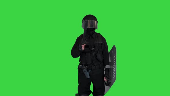 Riot Police Officer Talking and Making Gestures with Rubber Baton on a Green Screen Chroma Key