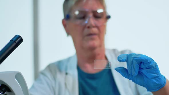 Elderly Scientist Checking Virus Evolution Looking at Samples