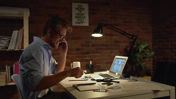 Young Architect with Light Beard and Blue Shirt Wearing Glasses Discussing on Mobile Phone Project