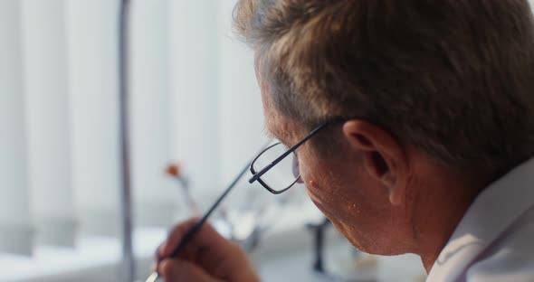 Closeup of Painting a Ceramic Dental Crown with a Thin Brush By Hand