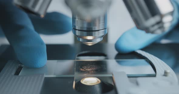 Close Up Shot of the Scientist Studies Examining of Test Sample Under the Microscope.