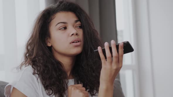 Beautiful African American Young Woman Hold Smartphone Use Digital Assistant on Device Black