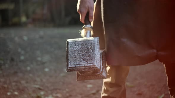 Blacksmith or Fairytale Character in Leather Apron Holds Fantastic Fantasy Huge Hammer in His Hands