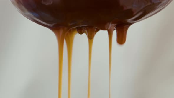 Closeup of Liquid Caramel Sauce Flowing Through a Sieve