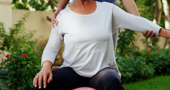 Female trainer assisting senior woman in exercising with dumbbells 4k