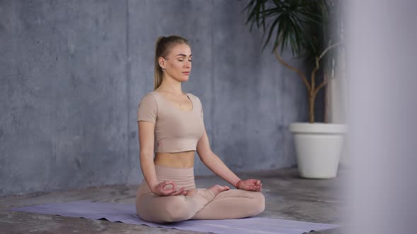 Lotus Pose or Padmasana with Closed Eyes and Holding Her Hands in Gyan Mudra