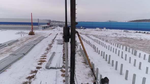 Aerial drone view of a hit part of pile bore machine at winter construction site 02