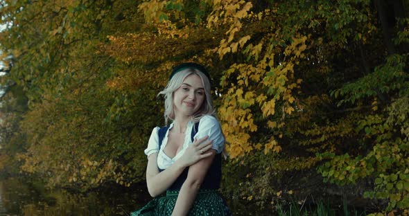 Slavic Girl in Costume Posing with a Smile on a Background of Autumn Trees