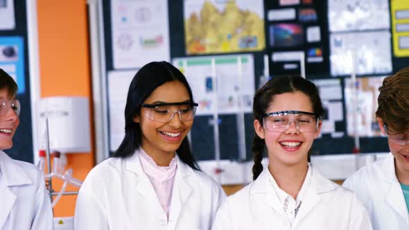 Smiling schoolkids interacting in laboratory