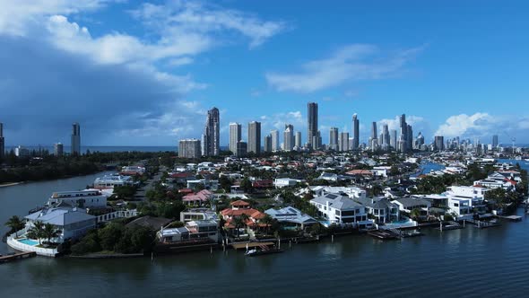 Prestige waterfront Gold Coast properties with a towering skyline city backdrop. drone view