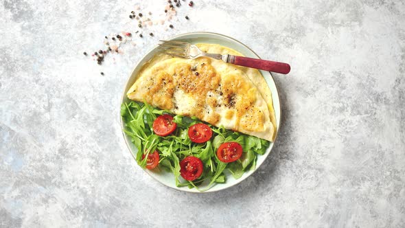 Classic Egg Omelette Served with Cherry Tomato and Arugula Salad on Side