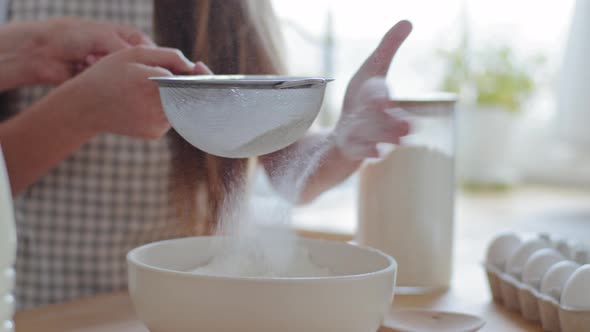 Close Up Female and Child Hands Holds Iron Sieve Sifts Wheat Flour Into Bowl Preparation of Dough