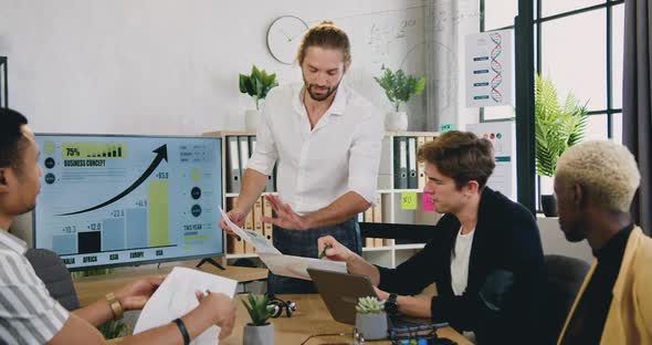 Male Team Working Together in Modern Office Room and Get Aquainted with Financial Report