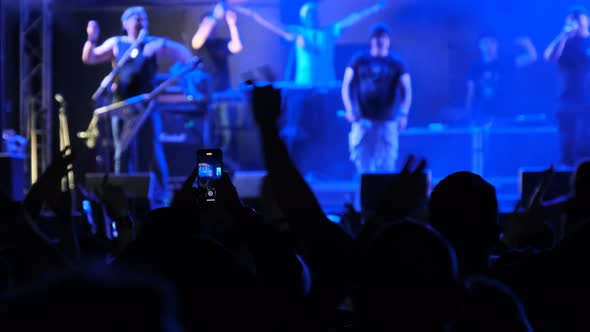 Crowd of People at a Rock Concert Raises His Hands Up and Applauds Fans