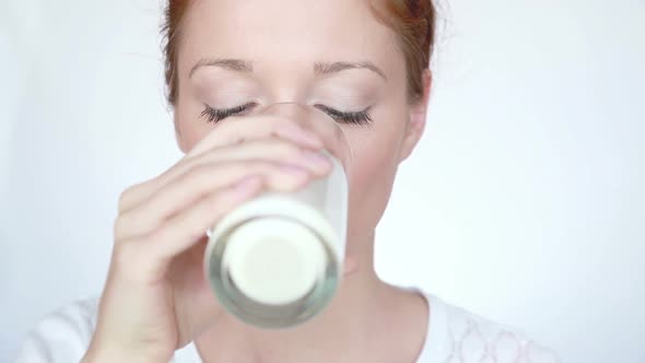 Woman Drinks Milk and Lick Off White Mustache
