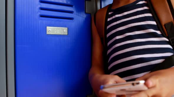 Schoolgirl using mobile phone in locker room 4k