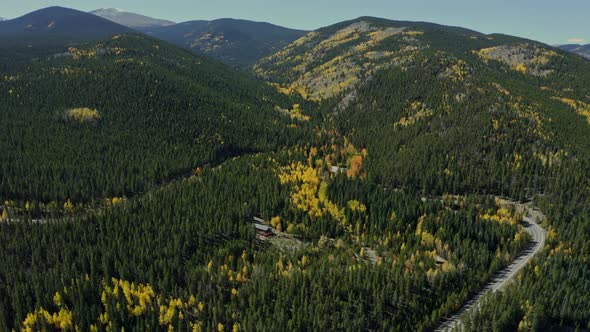 Landscape aerial of cabin surrounded by beautiful fall yellow forest road, 4K