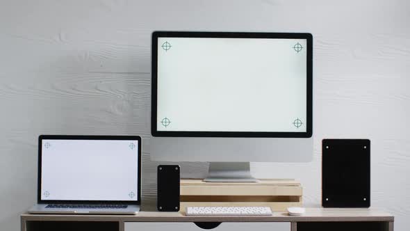 Video of laptop, smartphone, tablet and computer on wooden table with copy space in office