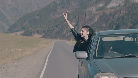 Young Woman Raises Hand To Sky and Gets Pleasure From Speed