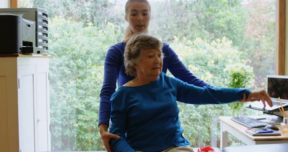 Physiotherapist stretching senior woman shoulder