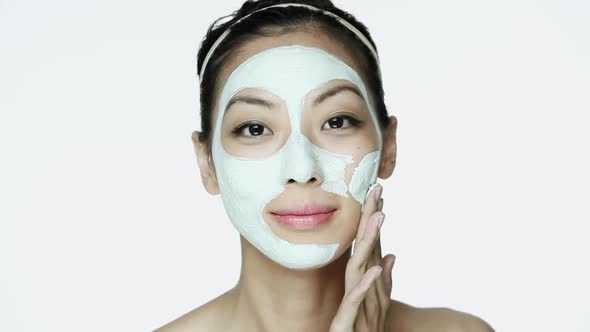 Young woman applying face mask