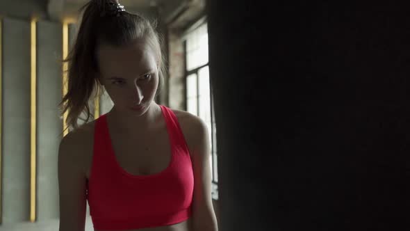 Woman in Boxing Gloves Beats a Punch Bag