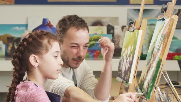 Mature Male Painter Artist Helping His Cute Daughter with a Painting